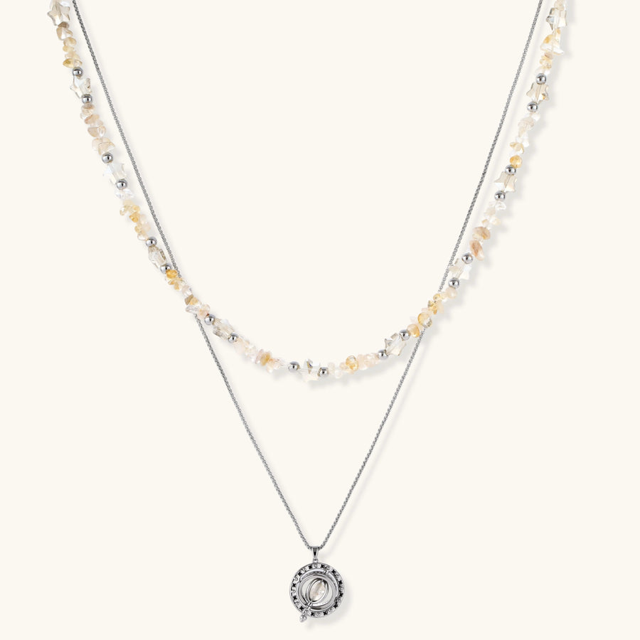 Two-layer necklace with natural stone chips and eco-brass beads, featuring a circular wrapped pendant on cream background.