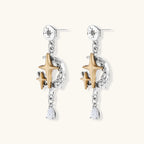 Two-tone star earrings with gold celestial motifs, silver chains, and clear crystal droplets on white background.