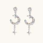 Detailed eco-brass dangle earrings featuring crescent moons with gold rope details and dangling star charms on white background.