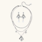 Ornate silver-toned masquerade mask jewelry set featuring rhinestone details and pearl drop earrings on white background.