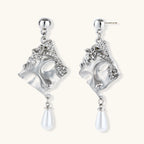 Ornate silver-toned masquerade mask jewelry set featuring rhinestone details and pearl drop earrings on white background.