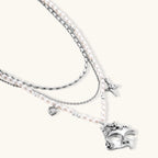 Ornate silver-toned masquerade mask jewelry set featuring rhinestone details and pearl drop earrings on white background.