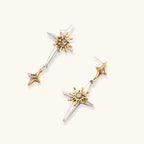 Layered silver-toned necklace set with cross pendant and gold sun charm detail, matching drop earrings on white background.
