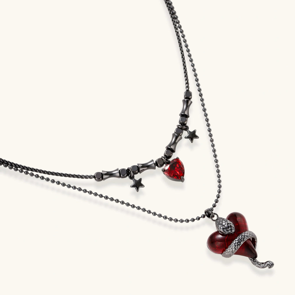 Gothic jewelry set with asymmetrical black metal earrings featuring red crescent moons, stars, and layered necklaces with heart pendants