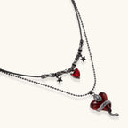 Gothic jewelry set with asymmetrical black metal earrings featuring red crescent moons, stars, and layered necklaces with heart pendants