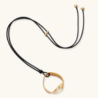 Geometric circle pendant necklace with crystal cluster on adjustable black cord, available in gold and silver finishes.