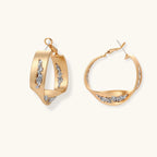 Gold circular pendant necklace with crystals on black cord paired with matching geometric hoop earrings on white background.