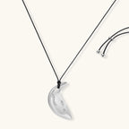 Adjustable crescent moon pendant necklace in gold and silver eco-zinc alloy with decorative engravings on black cord