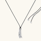 Adjustable black cord necklace with intricate silver-toned pendant featuring ornamental relief patterns and bead details.