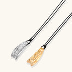 Adjustable black cord necklace with intricate silver-toned pendant featuring ornamental relief patterns and bead details.