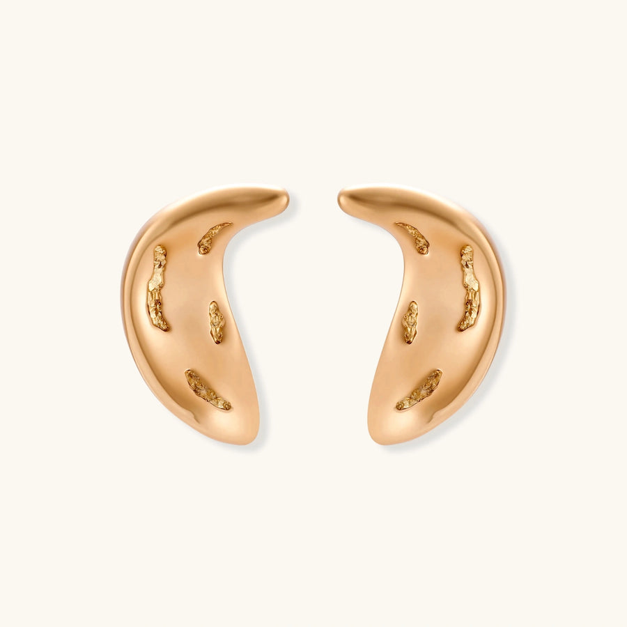 Pair of gold crescent moon-shaped stud earrings with textured surface details on cream background.