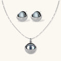Silver gray Tahitian-style pearl pendant necklace and matching pave zirconia stud earrings set on cream background.
