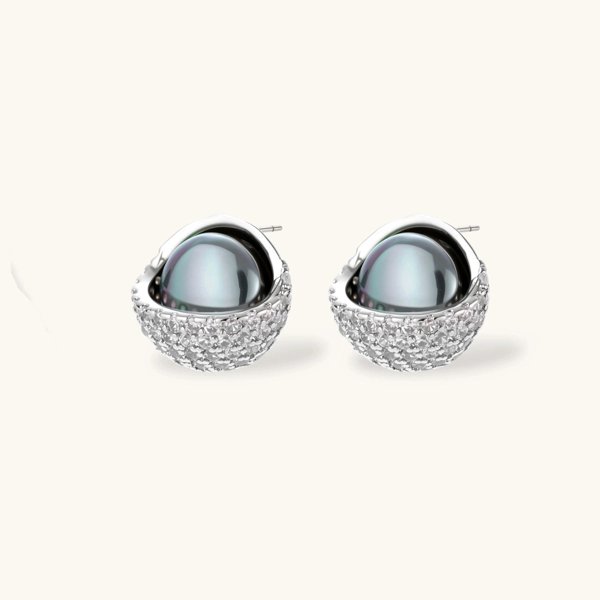 Silver gray Tahitian-style pearl pendant necklace and matching pave zirconia stud earrings set on cream background.