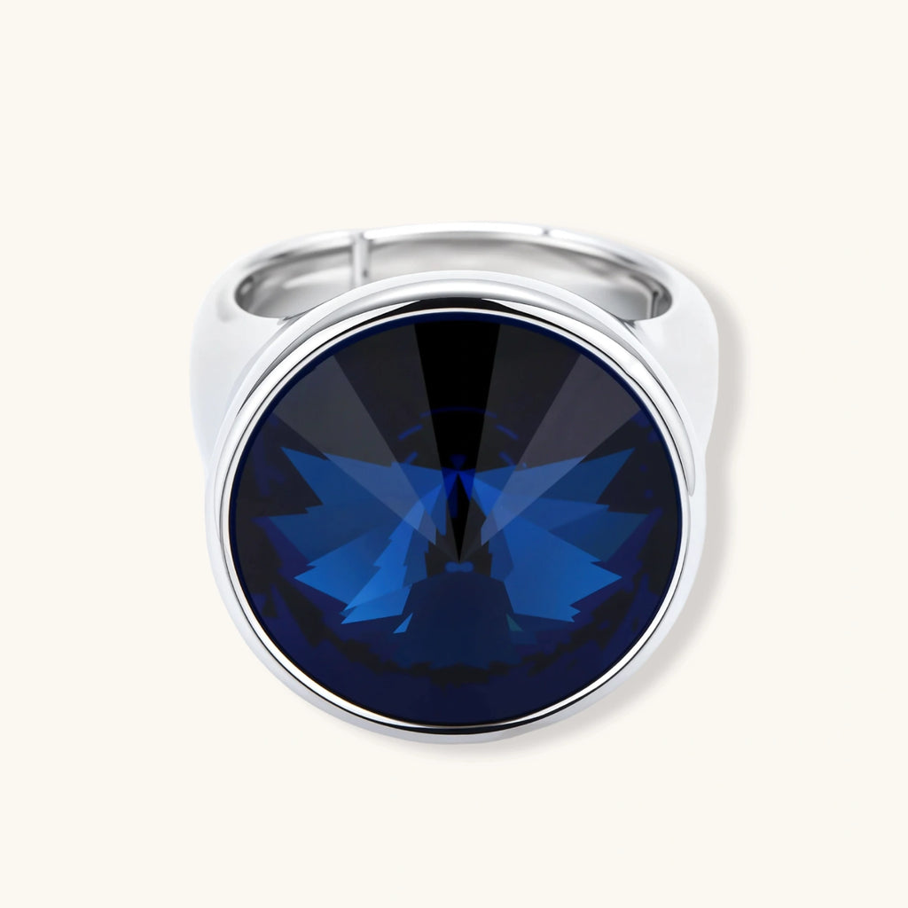 Large oval blue cubic zirconia ring in palladium-plated setting with adjustable band design on neutral background.