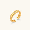 Gold open-band cuff ring with brushed matte finish, engraved 8-point star motifs, and round CZ stones on white background.